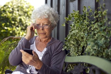 Home Doctor Practical Guide: Review Senior Woman Looking At Mobile Phone